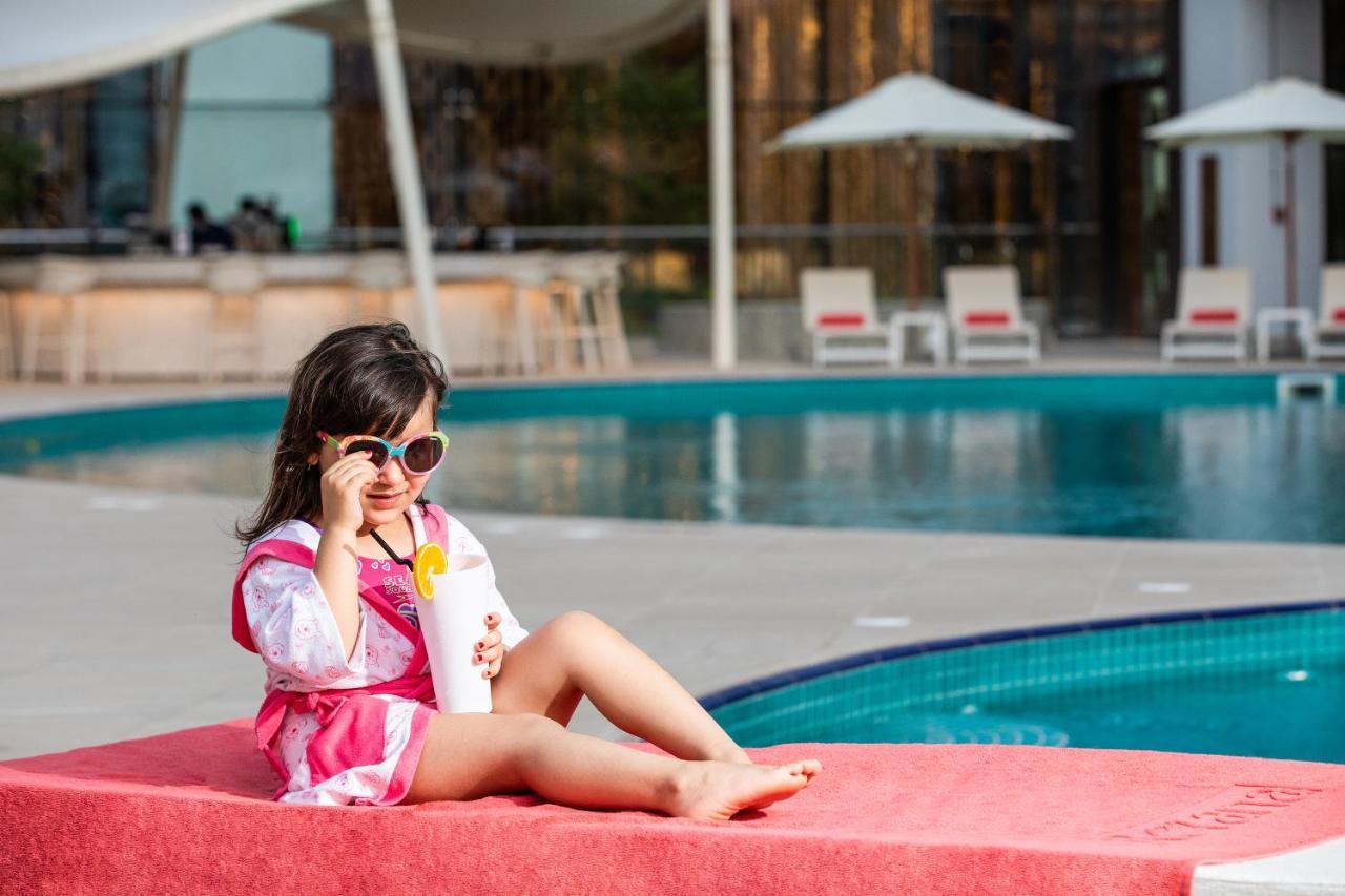 Al Jaddaf Rotana Suite Hotel Dubai Exterior photo A child wearing sunglasses